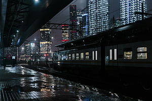 A train traveling through a city at night, Train Stations, HD wallpaper