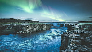 Body Of Water Between Rock Formation, water, rock, mountain, mountains, snow, sky, stars, aurora, nature, HD wallpaper